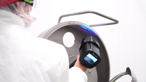 Worker using a BioDtex UV detection device to inspect a machine for hidden biofilm contamination
